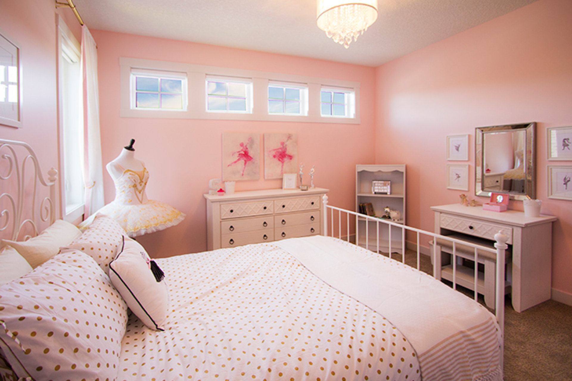 A child's pink bedroom with pink walls and matching furniture.
