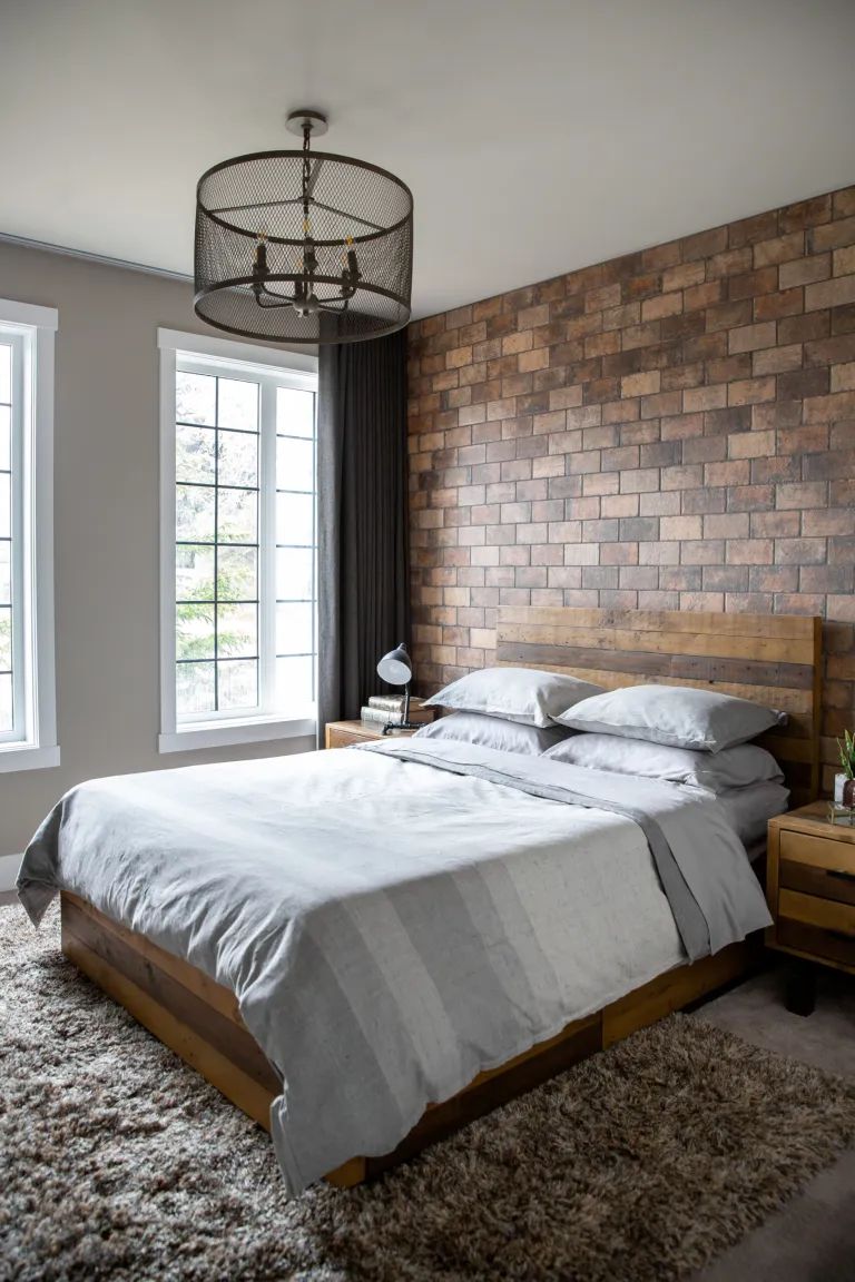 A condo bedroom decorated with a brick accent wall.