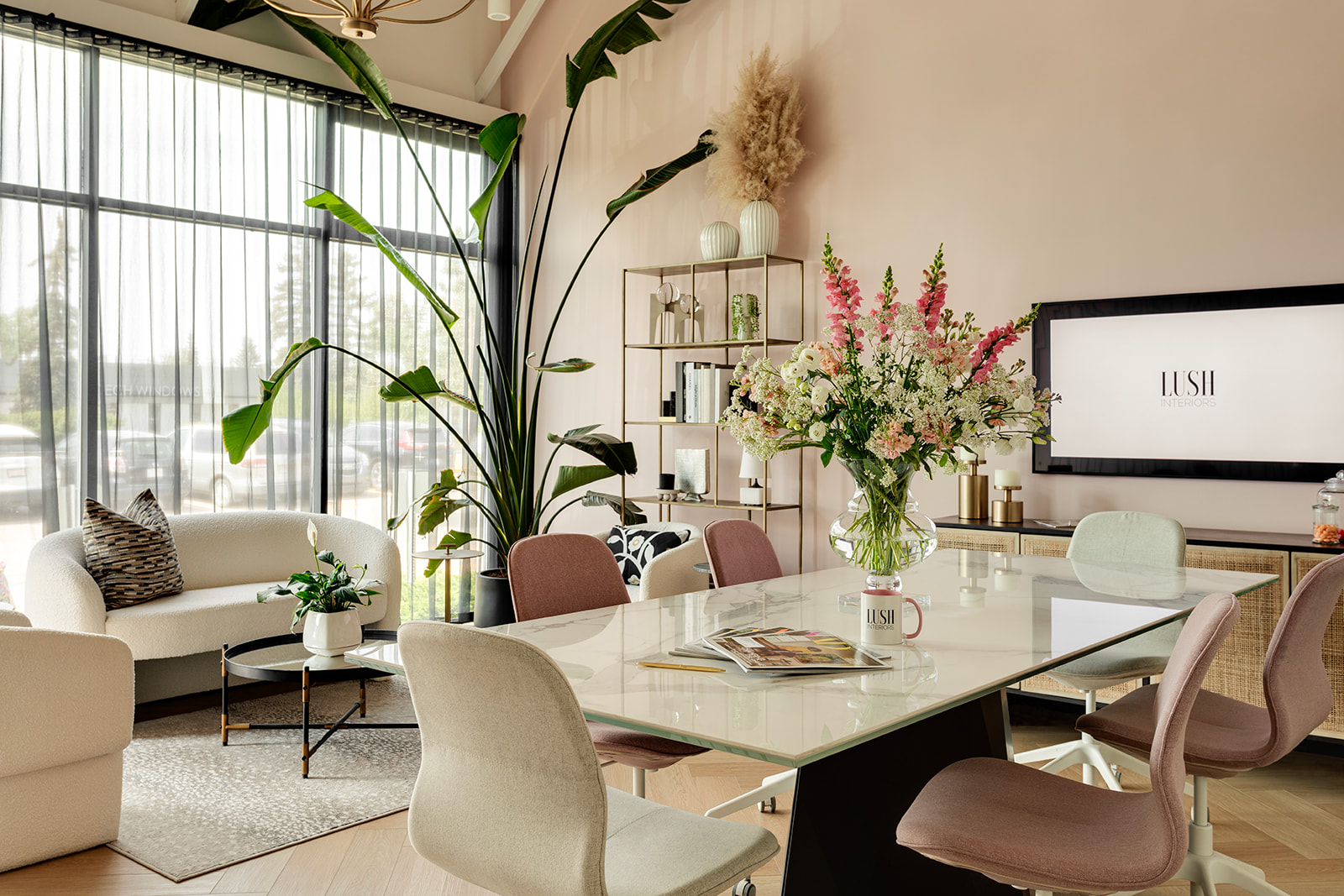 An interior design office with a large flower arrangement on a boardroom table.
