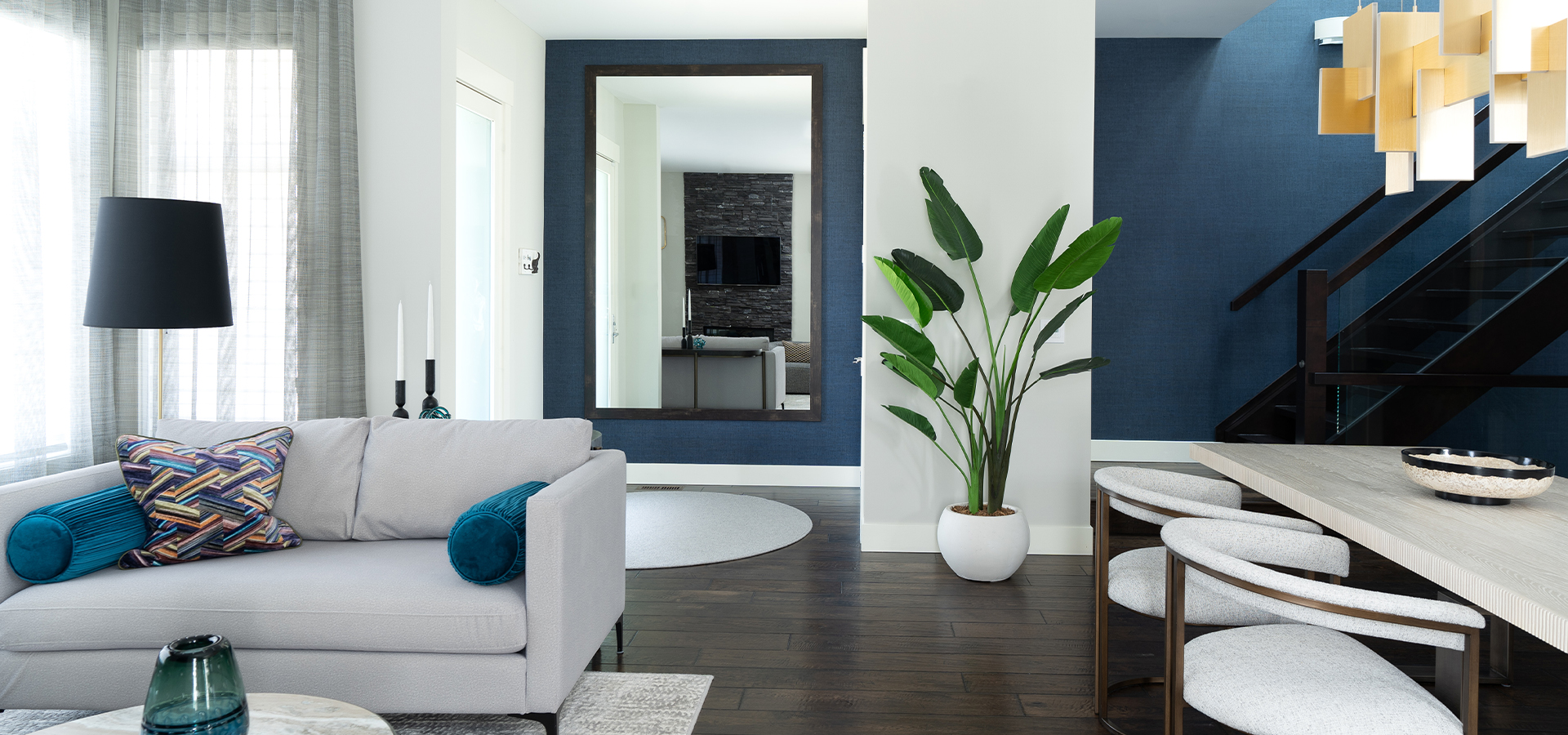 A modern room designed with off white furniture and dark blue accents.